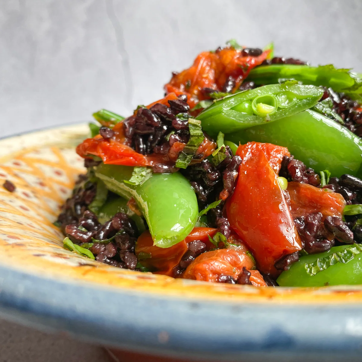 Black rice with sugar snaps and dried tomato